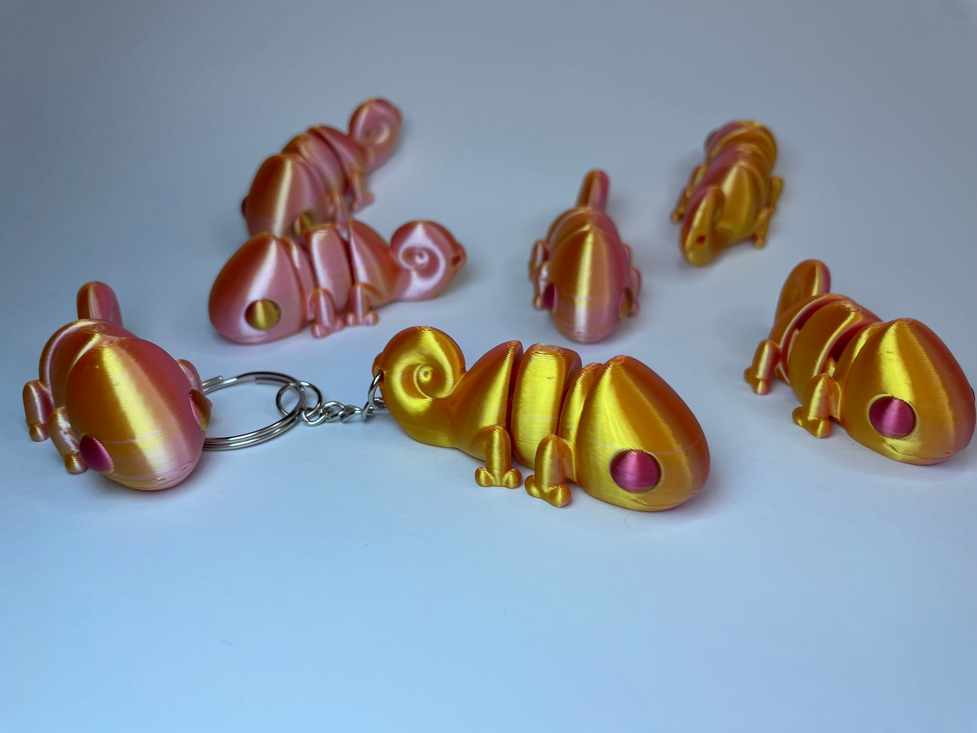 Seitenansicht des Flexi-Chamäleons Camillo – beweglicher 3D-Schlüsselanhänger aus schimmerndem Dual-Color-Silk PLA, gold-rosa