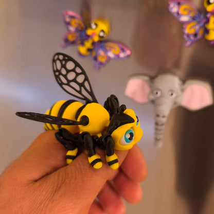 3D-gedruckter Bienen-Magnet Summi in der Hand, Seitenansicht, weitere Kühlschrankmagnete im Hintergrund, von 3DruckAS