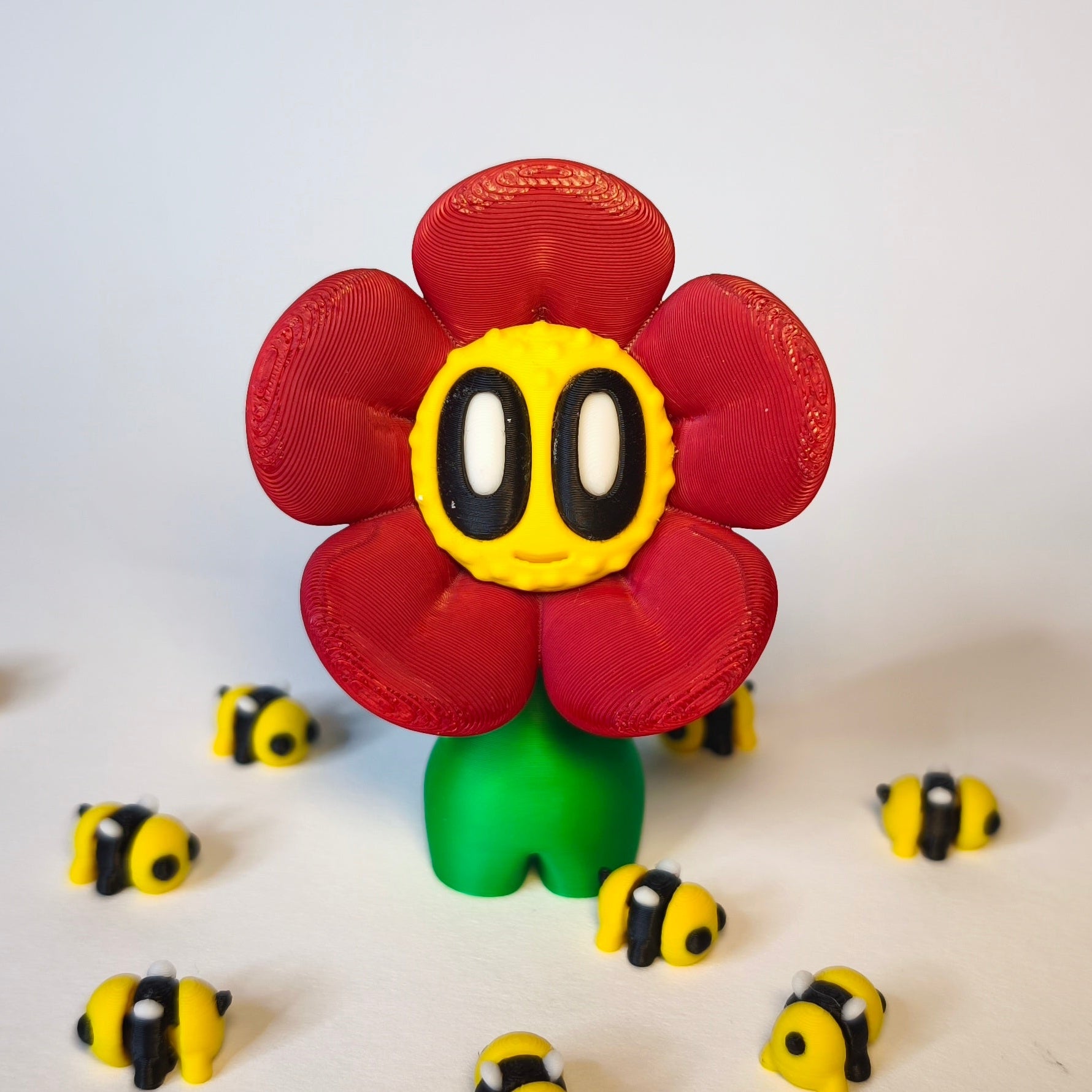 3D-gedruckte Blume ‚Daisy‘ mit Gesicht im Gänseblümchen-Stil in rot als Dekofigur