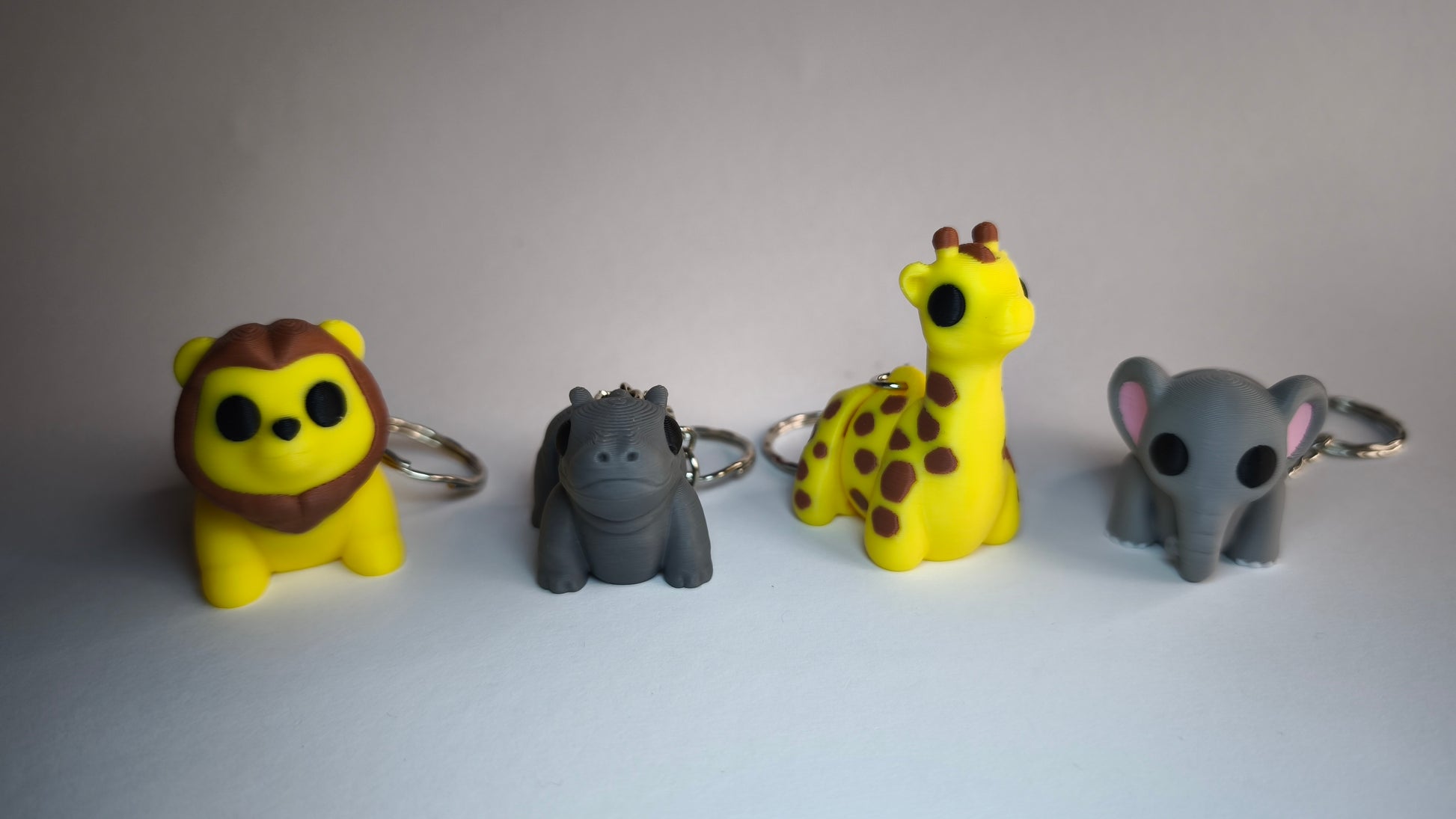 Flexi-Giraffe Raffi mit seinen Freunden – 3D-gedruckter Schlüsselanhänger in Gelb mit braunen Flecken