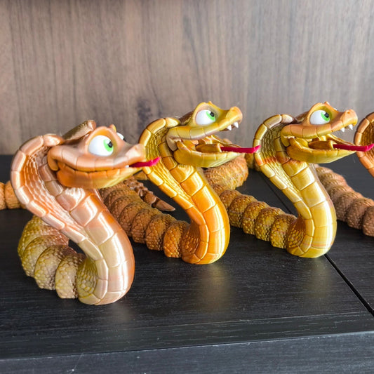 King Kobra – vier 3D-gedruckte Flexi-Cobras in Tricolor Silk PLA aufgereiht, verschiedene Gold/Kupfer/Silber-Farbnuancen, von 3DruckAS