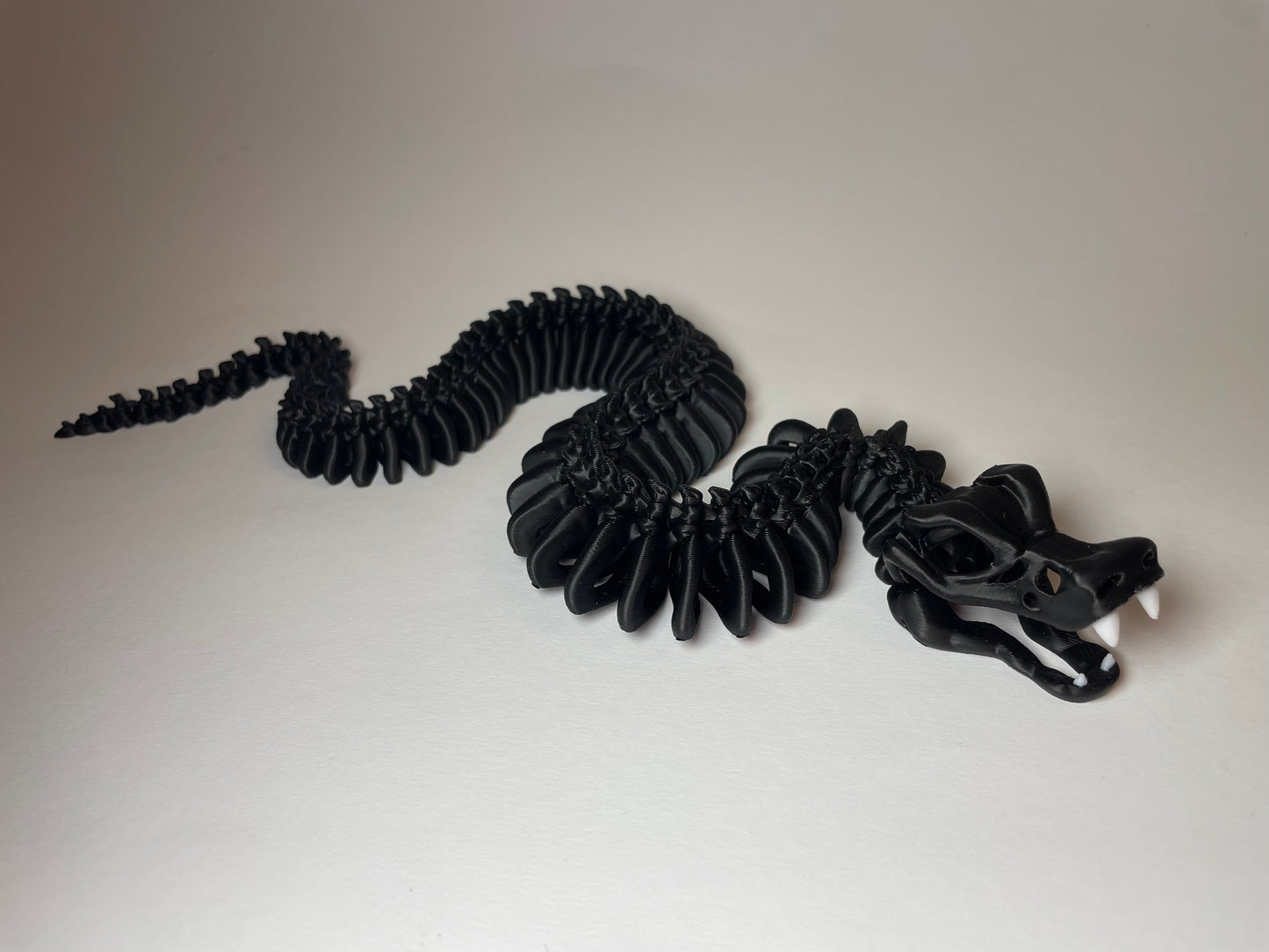 Little Flexi Skelett-Schlange in Schwarz mit weißen Zähnen aus 3D-Druck