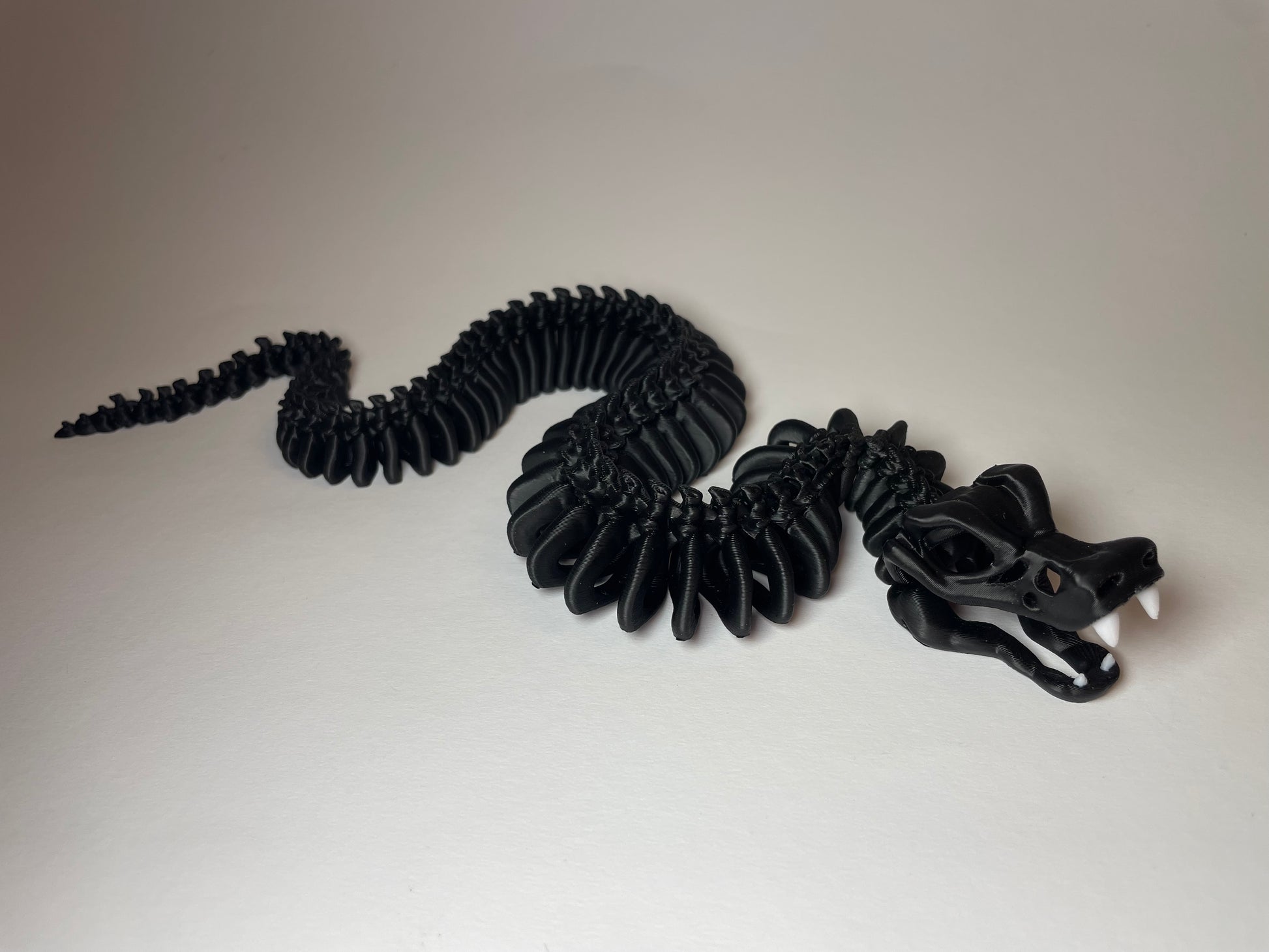Little Flexi Skelett-Schlange in Schwarz mit weißen Zähnen aus 3D-Druck