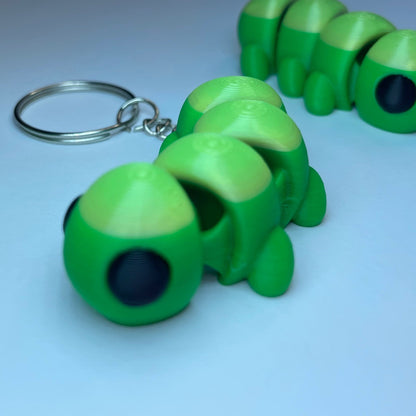 Flexi-Tierfigur Raupe Raupy – 3D-Schlüsselanhänger aus PLA, grün mit großen Augen.