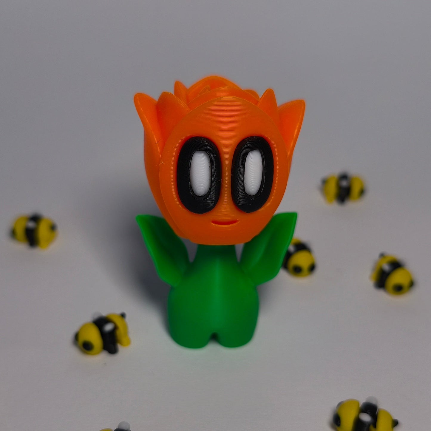 orange 3D-gedruckte Rosenblüte ‚Rosi‘ mit Gesicht als Dekofigur aus PLA