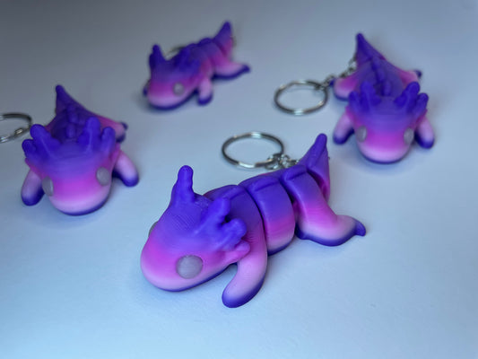 Saphira der Flexi-Axolotl – 3D-gedruckter Schlüsselanhänger in Lila-Pink aus nachhaltigem PLA.