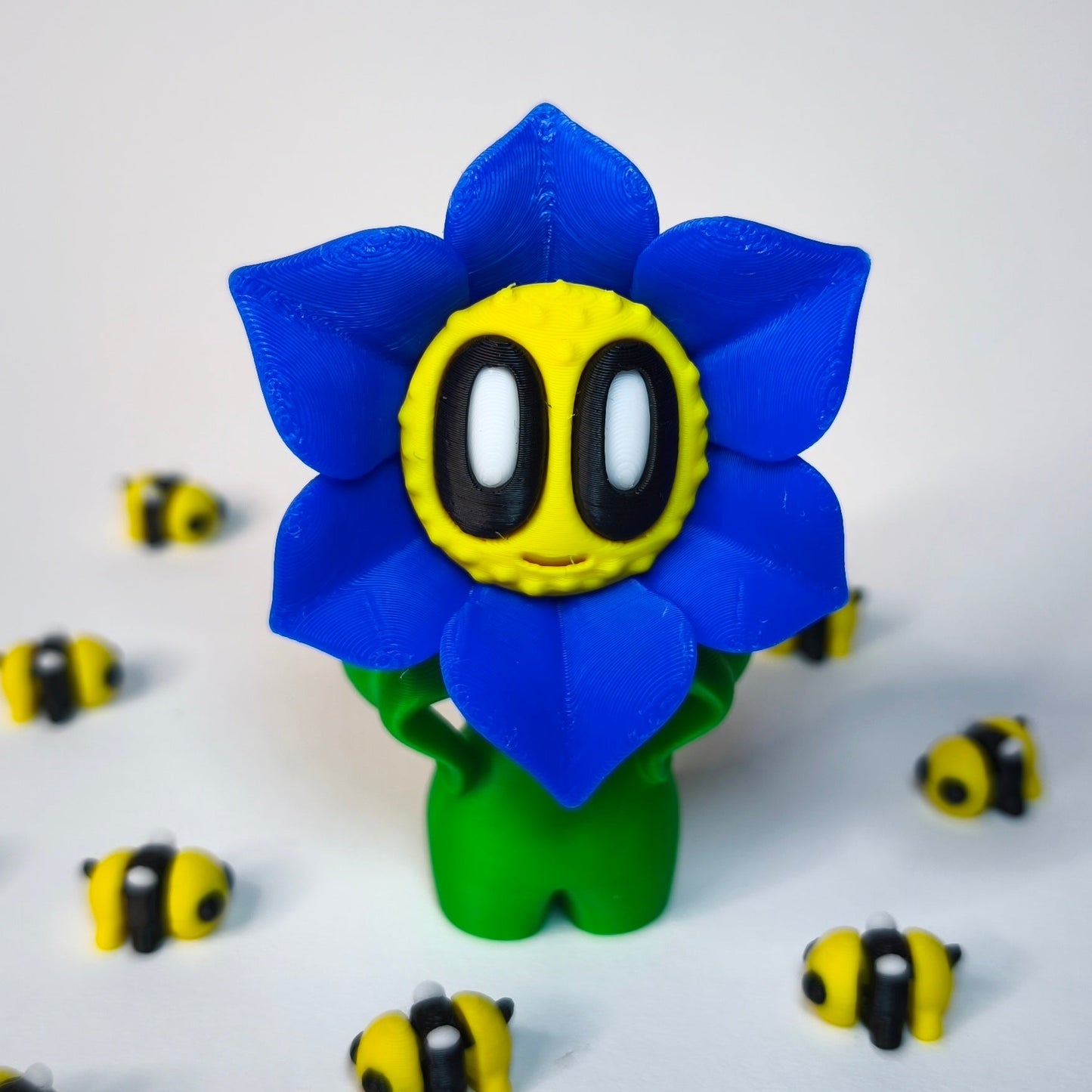 Blau 3D-gedruckte sternförmige Blume ‚Sternchen‘ mit Gesicht als Dekofigur in verschiedenen Farben